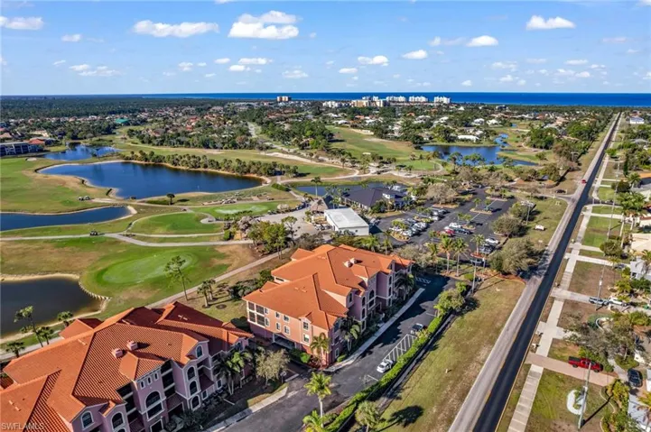 Aerial view of residential area featuring a local golf course and a nearby body of water