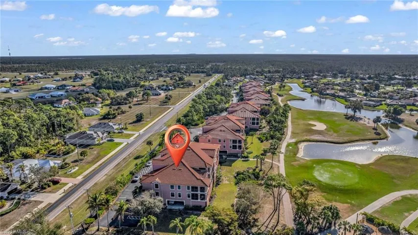 Aerial view of residential area featuring a golf club and a nearby body of water