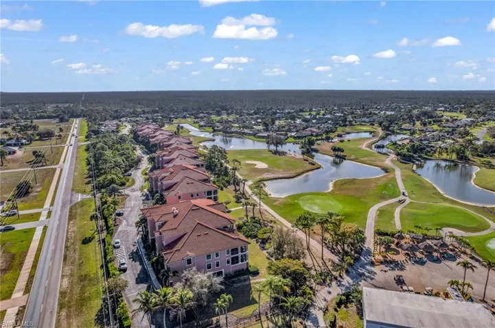 Aerial view of residential area with a golf club and a nearby body of water