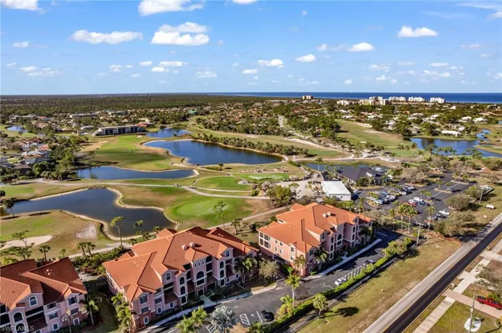Aerial perspective of suburban area with a golf club and a large body of water