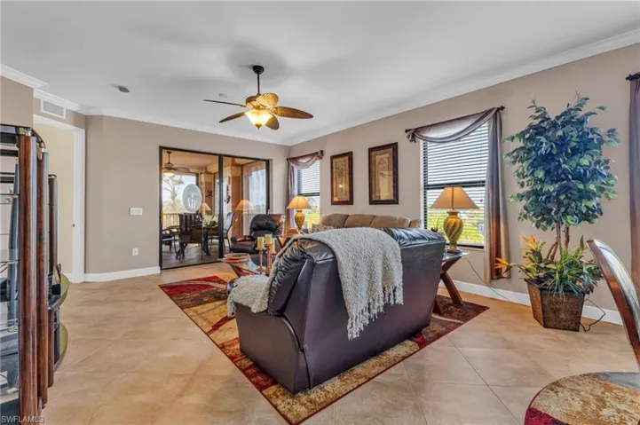 Bedroom featuring access to exterior, multiple windows, ornamental molding, ceiling fan, and light tile patterned floors