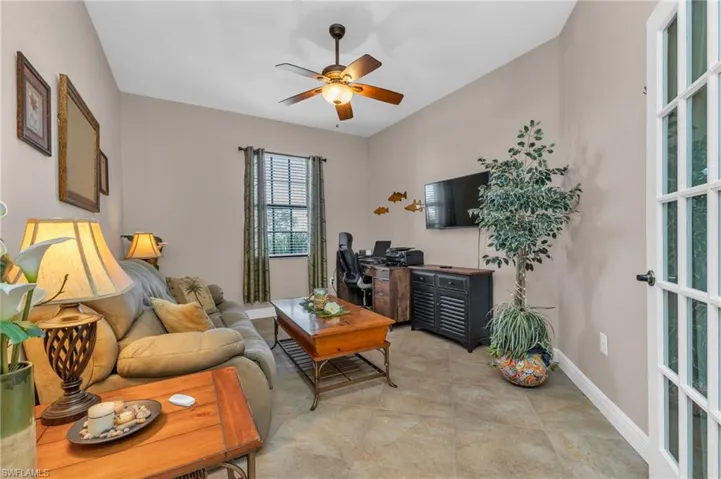 Living room featuring ceiling fan and baseboards