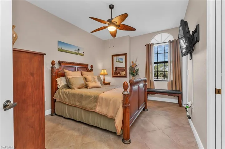 Bedroom with ceiling fan and light tile patterned flooring