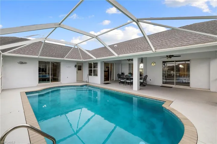 Outdoor pool with a ceiling fan, a patio, a sunroom, a lanai, and outdoor dining space