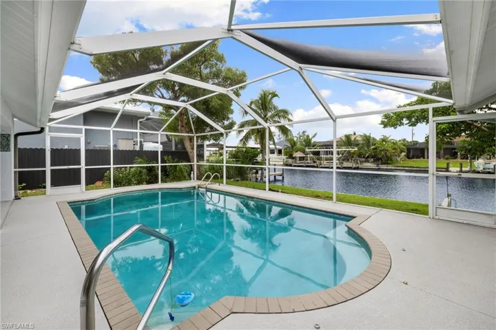Swimming pool featuring a lanai, a sunroom, a patio area, and a water view