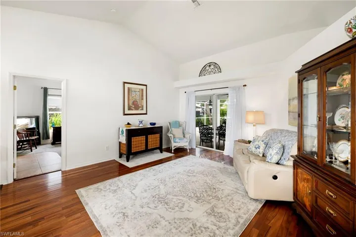 Living room with lofted ceiling and dark wood-style flooring