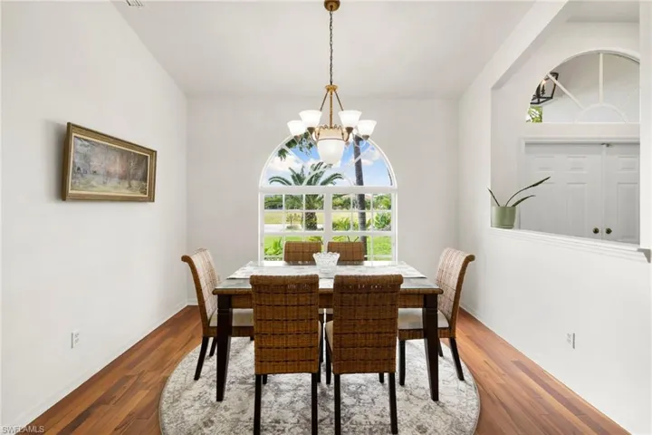 Dining area featuring dark wood-type flooring and a chandelier