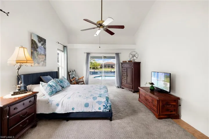 Bedroom featuring carpet, high vaulted ceiling, access to exterior, and a ceiling fan