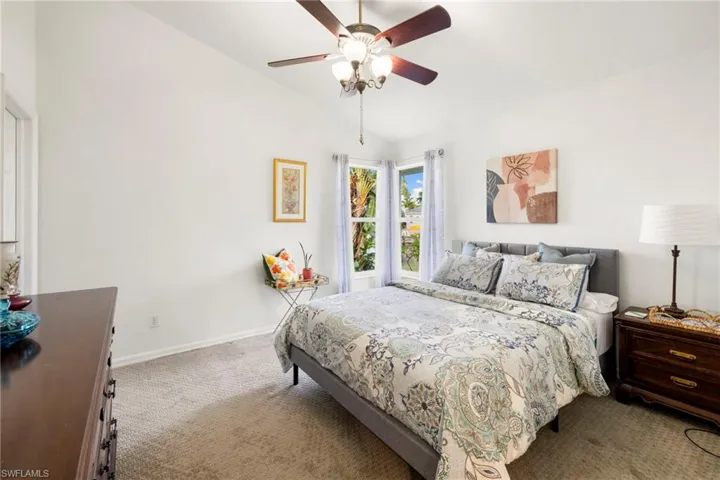 Bedroom featuring lofted ceiling, carpet flooring, and a ceiling fan