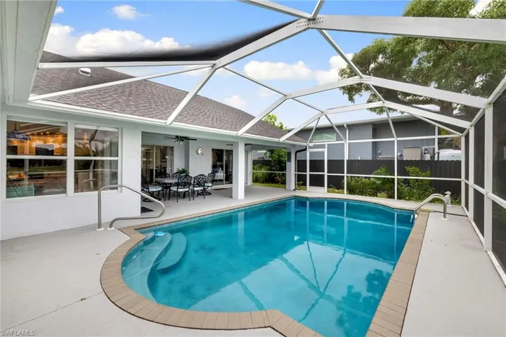 View of swimming pool featuring a sunroom, a lanai, a patio, and ceiling fan
