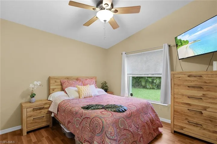 Bedroom featuring vaulted ceiling, light wood finished floors, and a ceiling fan