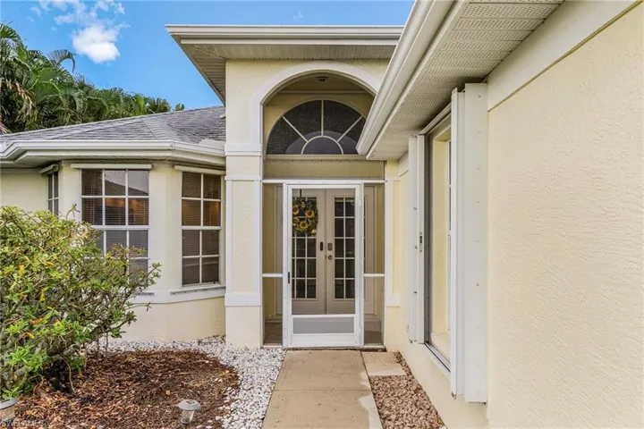 View of exterior entry with stucco siding and french doors. Newly screened.
