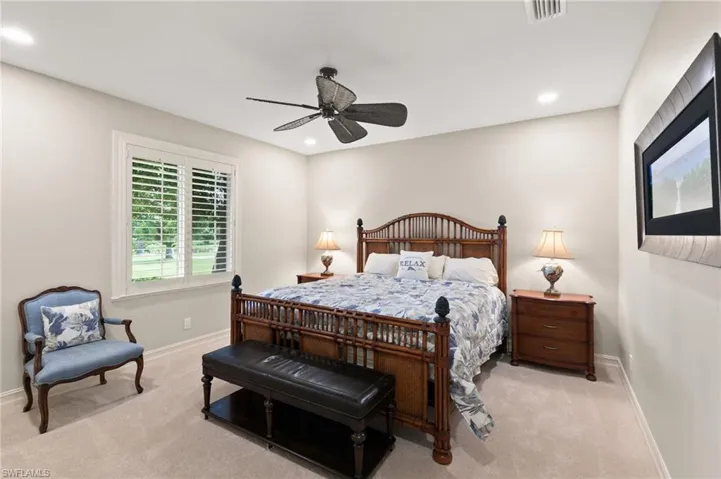 Carpeted bedroom featuring ceiling fan