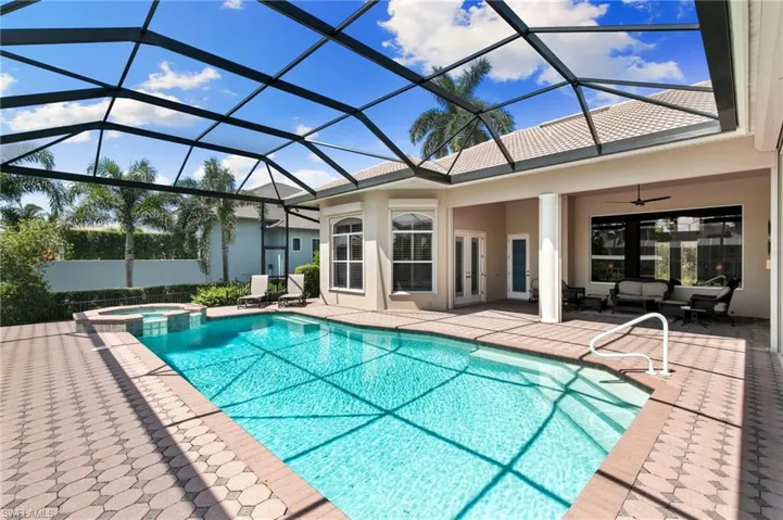View of pool with a patio, an in ground hot tub, ceiling fan, and glass enclosure