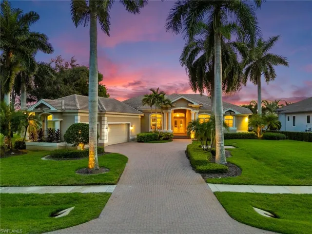 Ranch-style house with a garage and a lawn