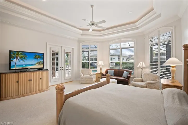 Bedroom with carpet floors, access to outside, ceiling fan, and a raised ceiling