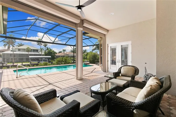 View of pool with a lanai, ceiling fan, french doors, and a patio area