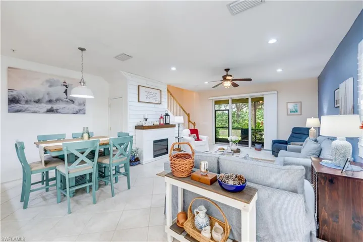 Living room featuring light tile patterned floors and ceiling fan