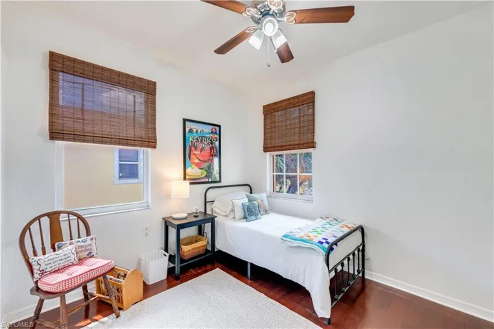 Bedroom with ceiling fan and dark hardwood / wood-style floors