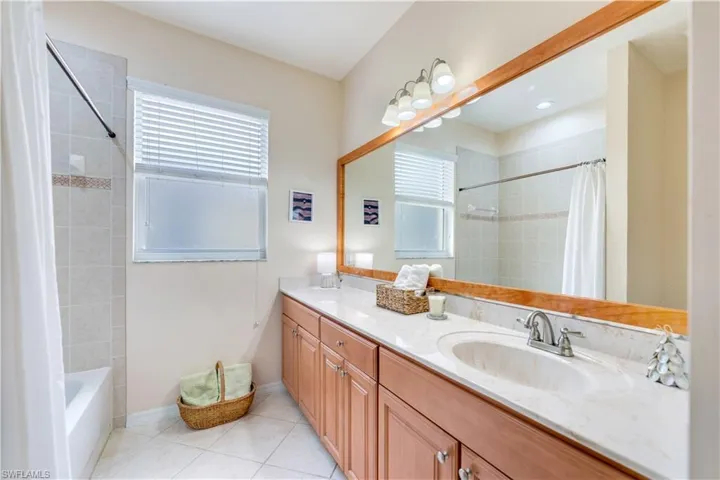 Bathroom featuring vanity, shower / bath combo, and tile patterned floors