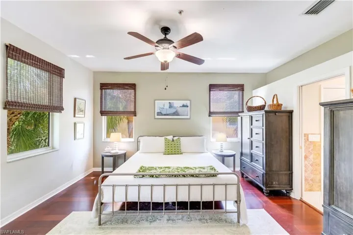 Bedroom with ceiling fan and dark hardwood / wood-style floors
