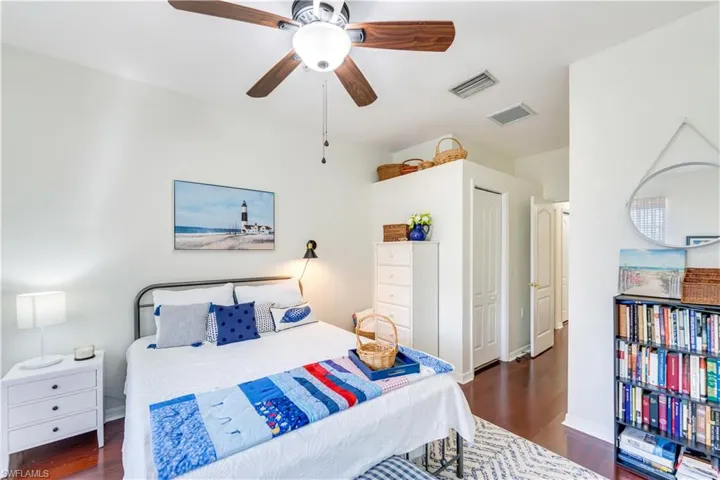 Bedroom featuring dark hardwood / wood-style floors, ceiling fan, and a closet