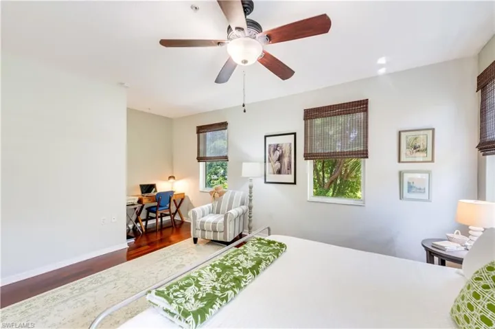 Bedroom featuring ceiling fan, dark wood-type flooring, and multiple windows