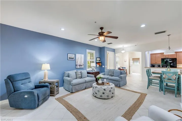 Living room with light tile patterned floors and ceiling fan