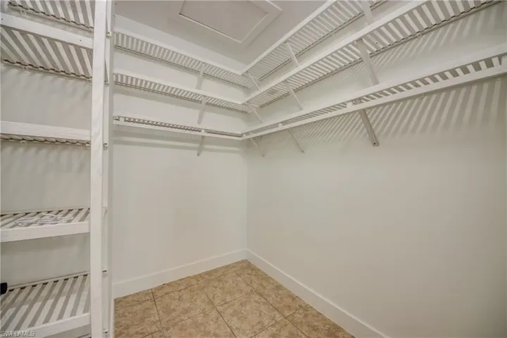 Walk in closet with light tile floors