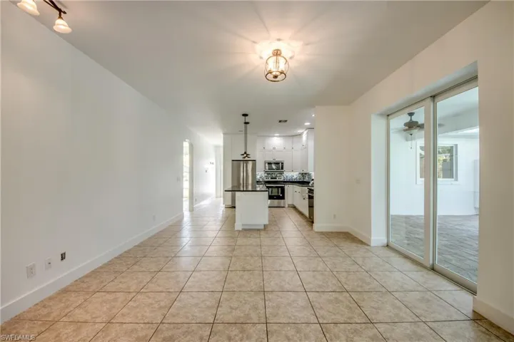Unfurnished dining area featuring ceiling fan and light tile floors