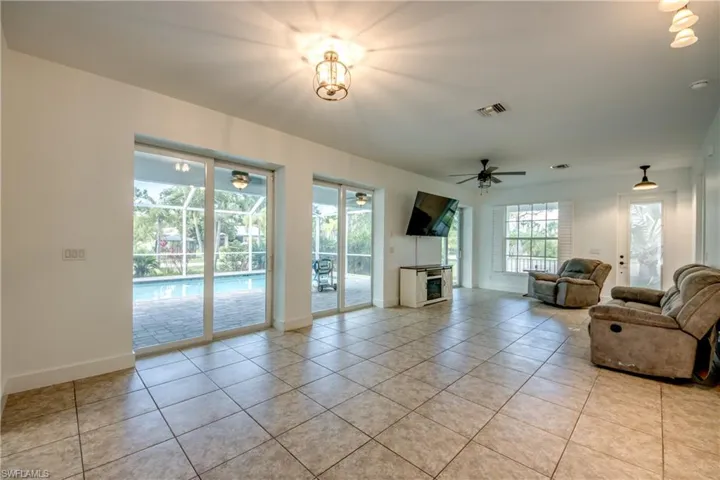 Living room featuring ceiling fan and light tile flooring