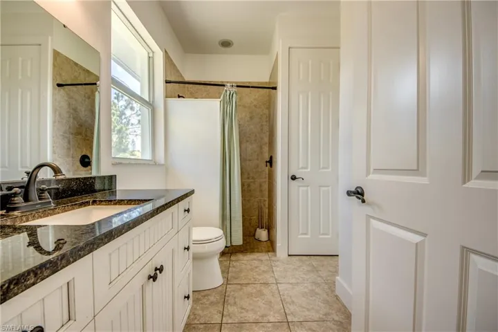 Bathroom with tile flooring, vanity, and toilet