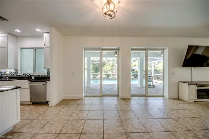 Kitchen with white cabinetry, tasteful back splash, light tile floors, and stainless steel dishwasher