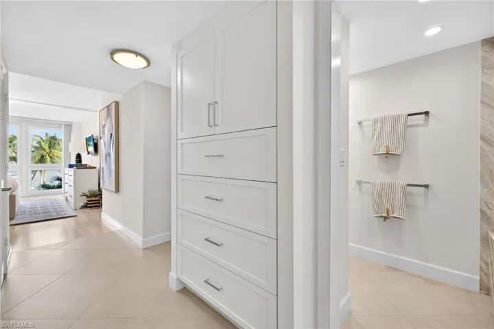 Hallway to bathroom with 2 walk in closets and storage on opposite side