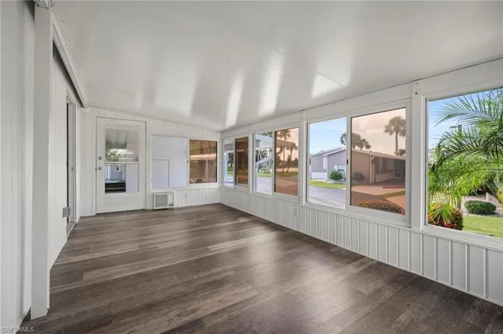 Unfurnished sunroom featuring vaulted ceiling and healthy amount of natural light