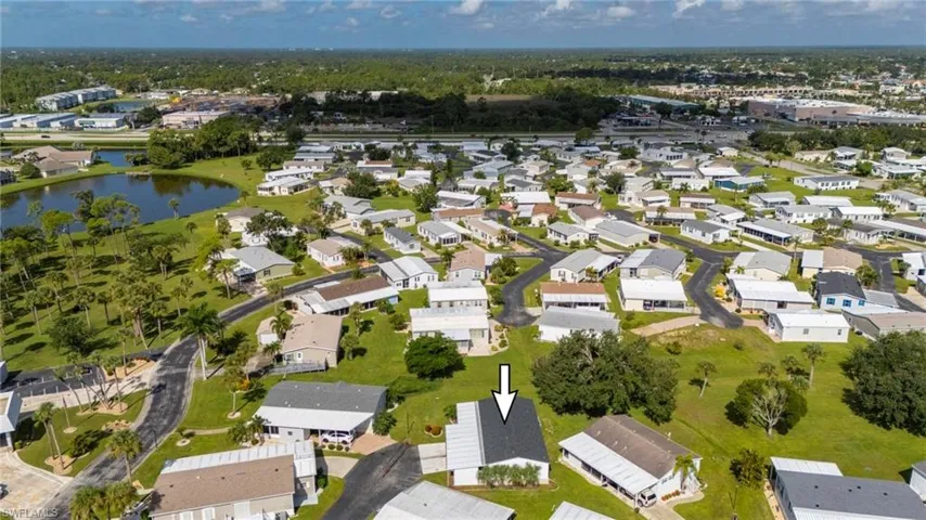 Aerial view of property and surrounding area featuring nearby suburban area and a nearby body of water