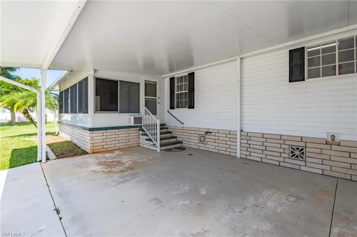 View of patio / terrace featuring a sunroom, entry steps, and an attached carport