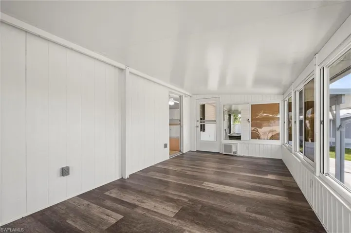 Unfurnished sunroom with wood finished floors and wood walls