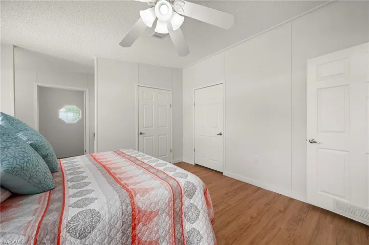 Bedroom with wood finished floors, a textured ceiling, and a ceiling fan