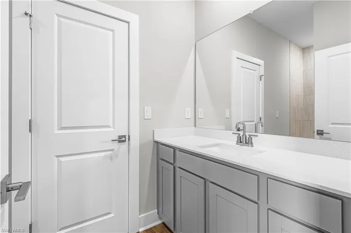 Bathroom with vanity and light carpet
