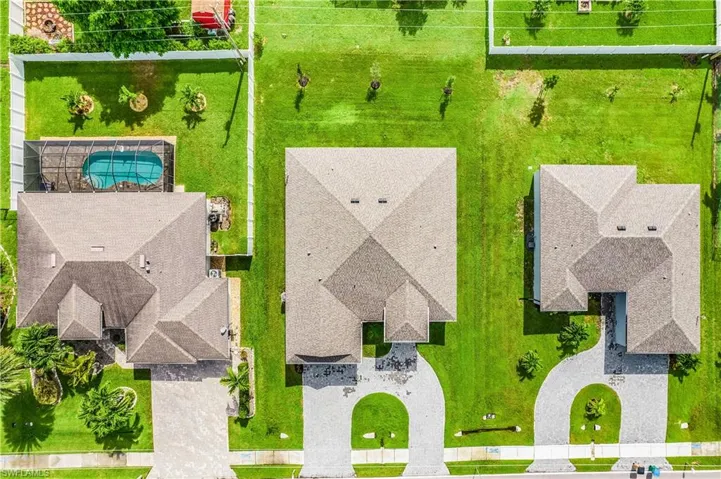 Back of property featuring a lawn, a patio, stucco siding, and a shingled roof
