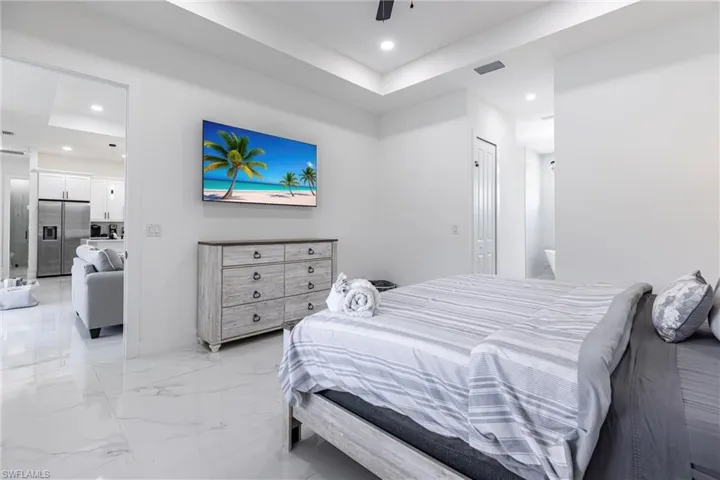 Bedroom with light marble finish floors, recessed lighting, ceiling fan, and a closet