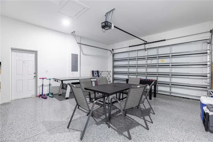 Garage featuring electric panel and a garage door opener