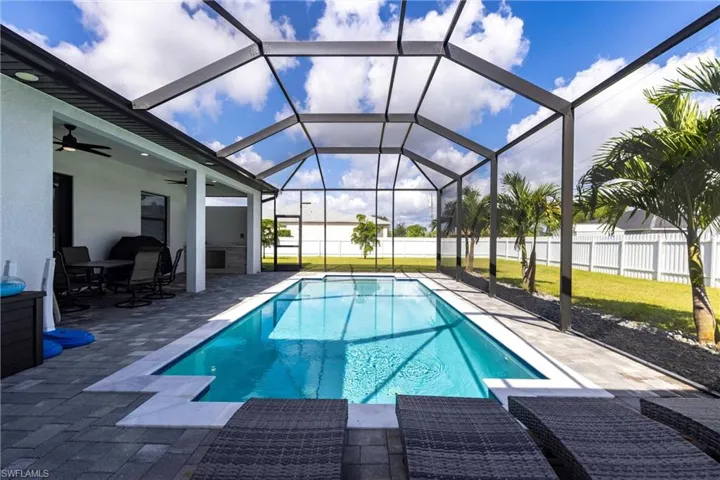 View of swimming pool with ceiling fan, a patio area, a sunroom, and a lanai