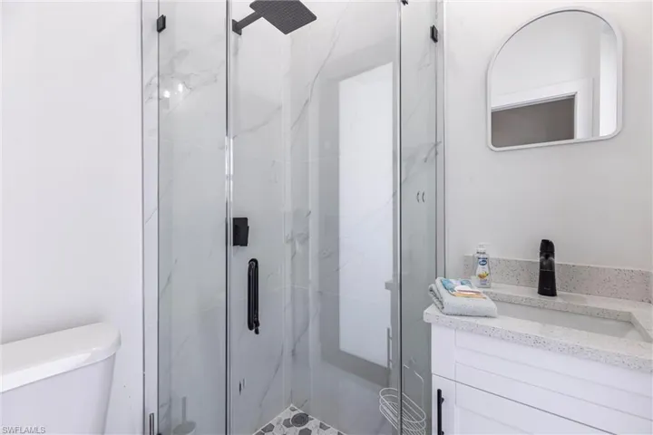 Bathroom with a marble finish shower and vanity