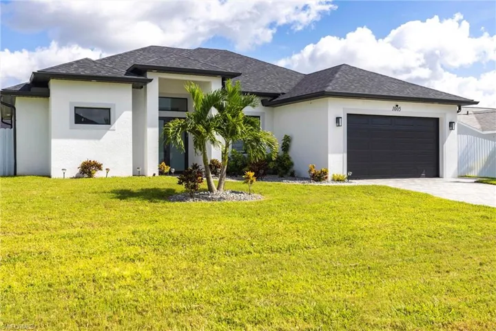 View of front of property with stucco siding, an attached garage, decorative driveway, and roof with shingles