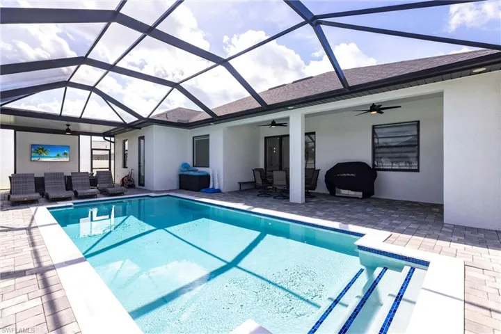 Swimming pool featuring ceiling fan, a sunroom, and a patio