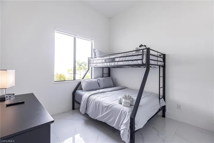 Bedroom with baseboards and light marble finish floors