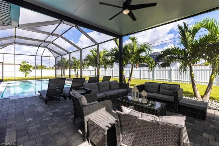 Fenced backyard featuring a patio area, outdoor lounge area, a sunroom and a ceiling fan