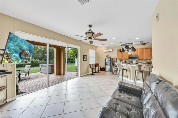 Living room featuring light tile patterned floors, recessed lighting, ceiling fan, and plenty of natural light
